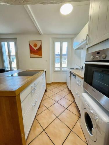 une cuisine avec un évier et une cuisinière four supérieur dans l'établissement Appartement de charme 2 pièces à Toulon, à Toulon