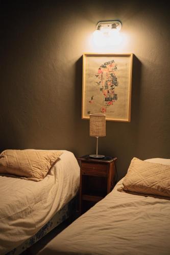 a bedroom with two beds and a picture on the wall at Chepatagonia Hostel & Coworking in Puerto Madryn