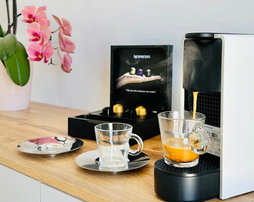 a coffee maker and two glasses on a counter at Anita Rooms & Suites Milos in Adamas