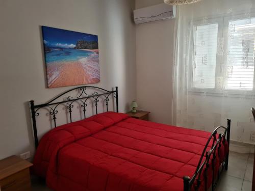 シラクーサにあるChiara Apartmentの赤いベッド1台(赤い毛布付)が備わるベッドルーム1室が備わります。