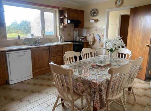 a kitchen with a table and chairs and a kitchen with a table and a kitchen at Sandfield View in Ardara