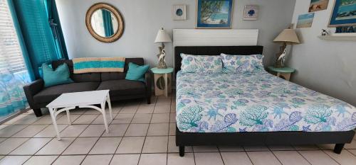 een slaapkamer met een bed en een bank bij Turquoise Beach Retreat~King Bed~Daytona Beach in Daytona Beach