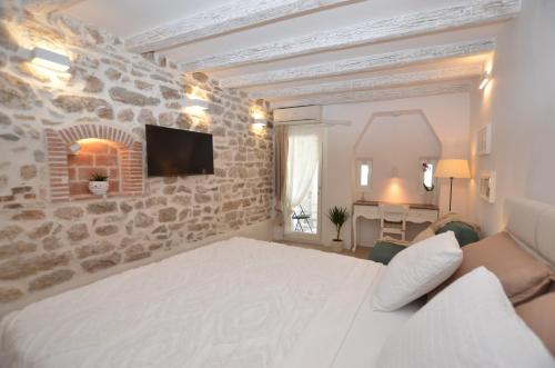 een slaapkamer met een wit bed en een stenen muur bij Apartment Al Pozzo in Rovinj