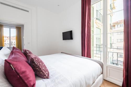 une chambre avec un lit avec des oreillers et une fenêtre dans l'établissement 3 SMOLETT - Appartement 2 pieces LUXE - Climatisé - ACROPOLIS, à Nice