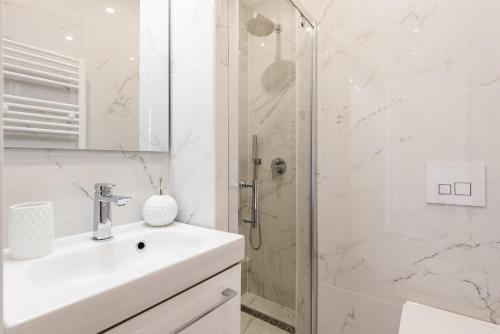 une salle de bain blanche avec un lavabo et une douche dans l'établissement 3 SMOLETT - Appartement 2 pieces LUXE - Climatisé - ACROPOLIS, à Nice