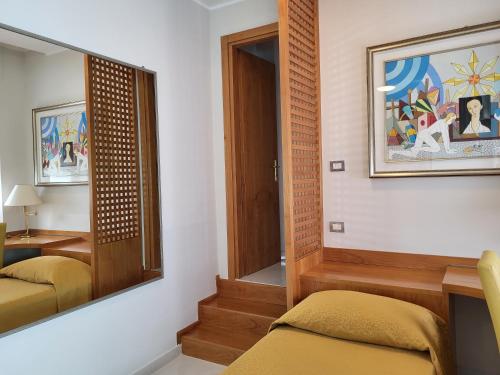 a room with a mirror and a chair and a table at Hotel Dei Fiori in Milan
