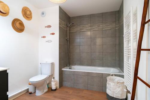 a bathroom with a toilet and a bath tub at Îlots Dido - Appt proche de la mer in Concarneau