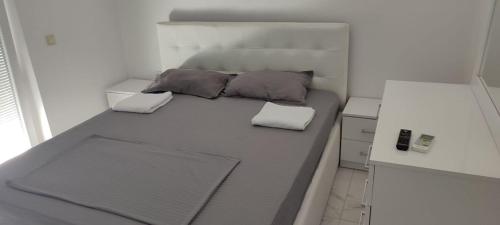 a bed in a small room with two pillows on it at Golem Apartment in Golem