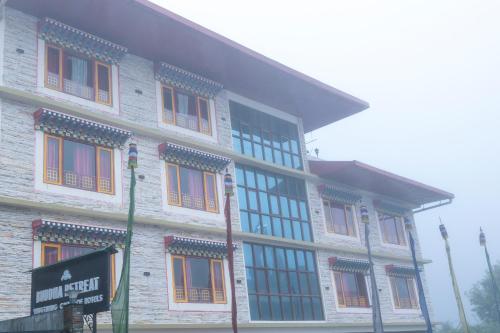 a large building with many windows on a street at Buddha Retreat in Ravangla