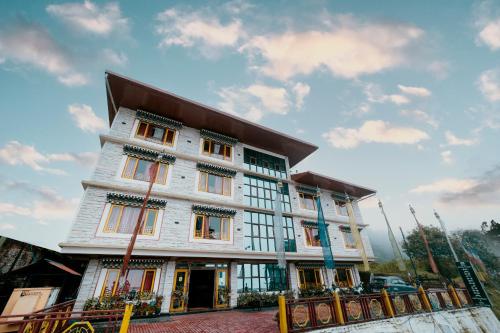 un edificio blanco con muchas ventanas en Buddha Retreat en Ravangla