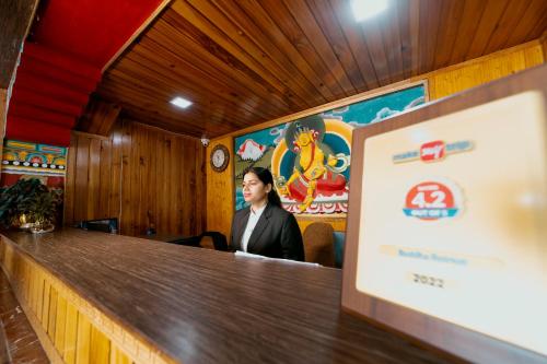 a woman standing behind a bar in a restaurant at Buddha Retreat in Ravangla