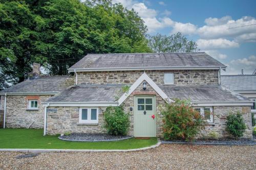 a stone house with a green door at The Lodge - 2 Bedroom Cottage - Princes Gate in Ludchurch