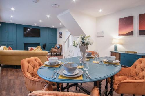 a living room with a blue table and chairs at The Lodge - 2 Bedroom Cottage - Princes Gate in Ludchurch