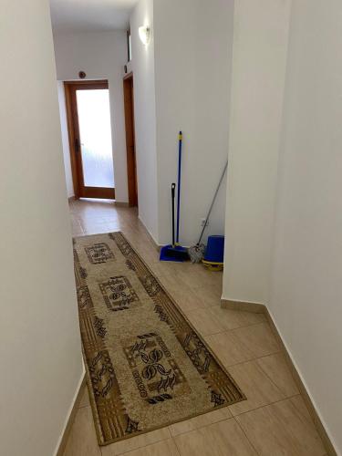 a hallway with a rug on the floor and a door at Къща за гости Уют in Sveti Vlas