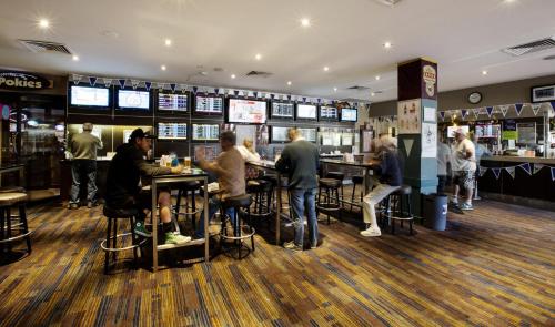 a group of people sitting at tables in a bar at Palm Beach Hotel in Gold Coast