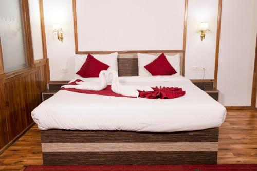 a bedroom with two beds with red and white pillows at Buddha Retreat in Ravangla