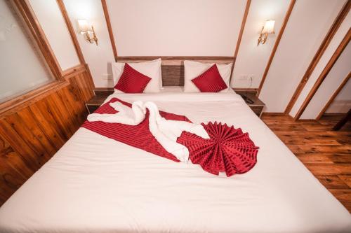 a bed with red and white towels on it at Buddha Retreat in Ravangla