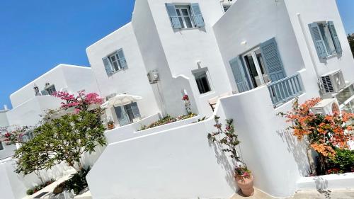 a white building with flowers in front of it at Anita Rooms & Apartments in Adamantas