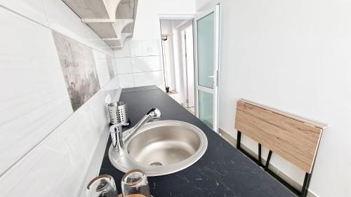 - une petite salle de bains avec lavabo dans l'établissement Belle Apartments - Central, à Piteşti