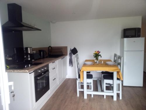 - une petite cuisine avec une petite table, une table et des chaises dans l'établissement Ô lac, à Tresserves