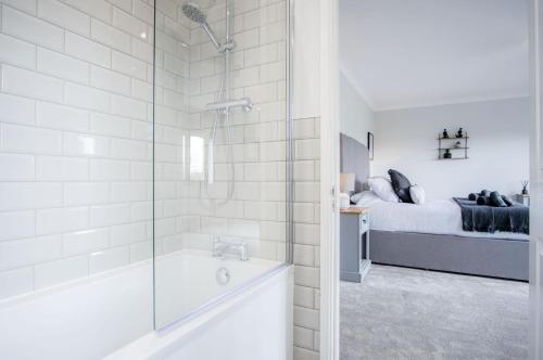 a bathroom with a shower and a tub and a bed at Springfield Lodge - 3 Bedroom Home - Princes Gate in Pembrokeshire