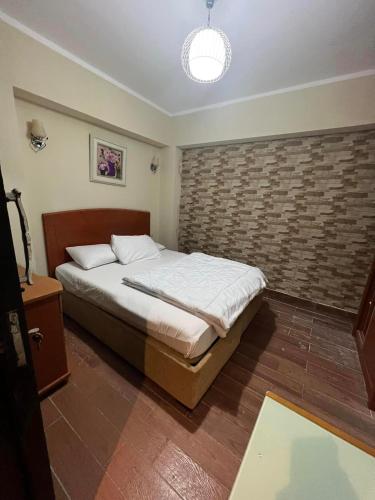 a bedroom with a bed and a brick wall at شاليه بورتو مارينا على البحر in El Alamein