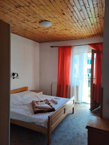 a bedroom with a bed with a wooden ceiling at Guesthouse Ukus Durmitora in Žabljak
