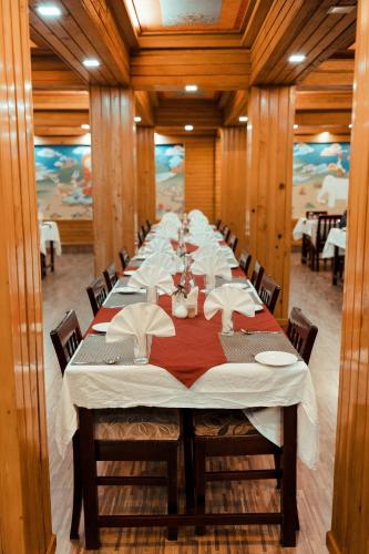 a long dining room with a long table with chairs at Sikkim Tourist Centre in Pelling