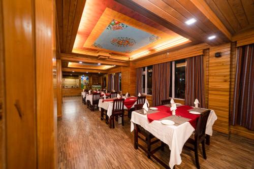a restaurant with tables and chairs in a room at Sikkim Tourist Centre in Pelling