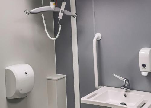 a bathroom with a sink and a hair dryer at Haystax Holiday Lodges in Knitsley