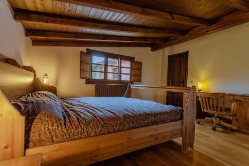 a bedroom with a bed in a room with wooden ceilings at Casa de campo con piscina, entera o por habitaciones in Amoeiro