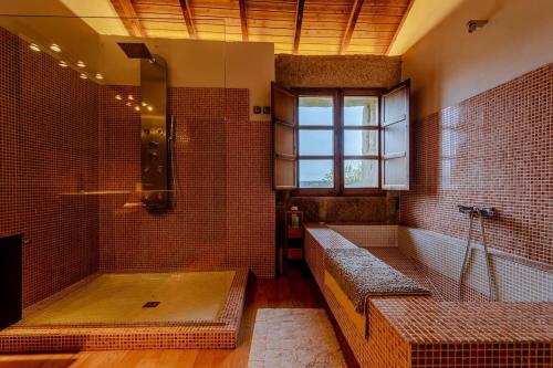 a large bathroom with a shower with a bench in it at Casa de campo con piscina, entera o por habitaciones in Amoeiro