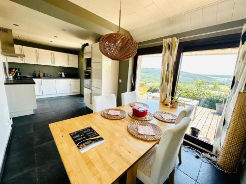 een keuken en eetkamer met een houten tafel met stoelen bij L'inspiration in Stavelot