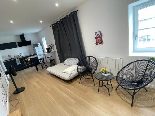 ein Wohnzimmer mit Sofa und Stühlen in der Unterkunft Appartement T2 à centre ville in Brive-la-Gaillarde