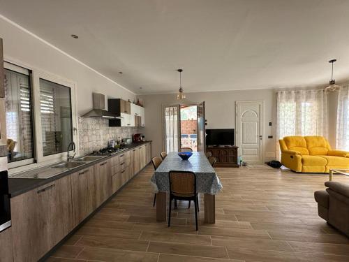 eine Küche und ein Esszimmer mit einem Tisch und gelben Stühlen in der Unterkunft Villa Valentina in Cefalú