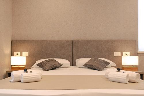 a bedroom with a bed with towels and two lamps at Palazzo Borgo Trento - Royal Welcome in Verona