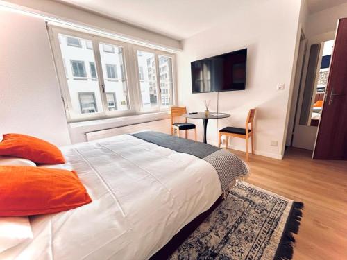 a bedroom with a large bed and a table with chairs at Cozy Studio Apartment Unit 11 in Center of Zurich in Zurich