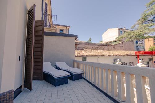 a balcony with two benches on the side of a building at Palazzo Borgo Trento - Royal Welcome in Verona