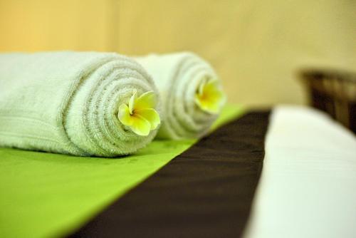 a close up of towels with flowers on a bed at Hotel Athgira in Udawalawe