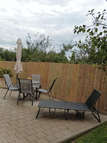 a patio with a table and chairs and an umbrella at Domček v záhrade in Liptovský Mikuláš
