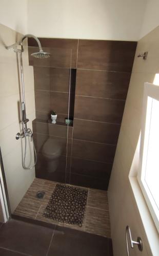 a shower with a glass door in a bathroom at Aegean View in Ermoupoli