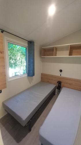 mały pokój z 2 łóżkami i oknem w obiekcie L'ARDECHO MODULO w mieście Saint-Lager-Bressac