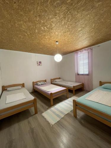 Cette chambre comprend 3 lits et un plafond. dans l'établissement Bartula Hut in Nature, à Bar