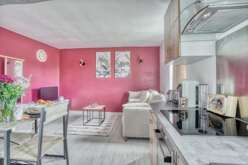 eine Küche mit rosa Wänden und ein Wohnzimmer in der Unterkunft Le Rubis de Gonesse •CDG•Parc Expo•Astérix in Gonesse