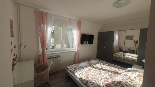ein kleines Schlafzimmer mit einem Bett und einem Fenster in der Unterkunft Apartment Pupi in Rijeka