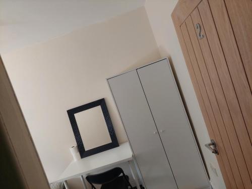 a mirror and a chair next to a dresser with a mirror at Double room in Lees