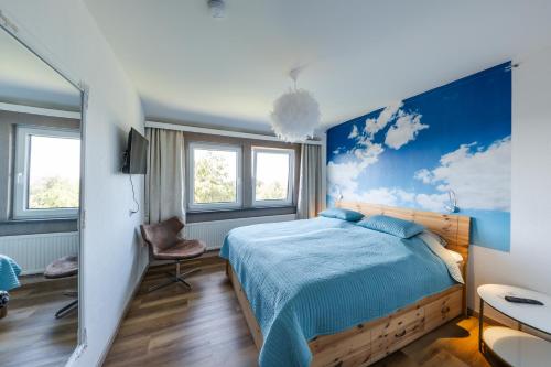 um quarto com uma cama com uma parede azul em Berghotel Hohegeiß em Hohegeiß