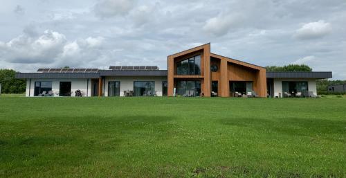 a house with a green field in front of it at Idille1 in Ikšķile