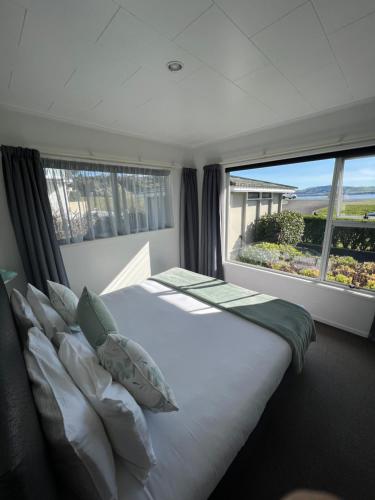 - une chambre avec un grand lit et une grande fenêtre dans l'établissement Accent On Taupo Motor Lodge, à Taupo