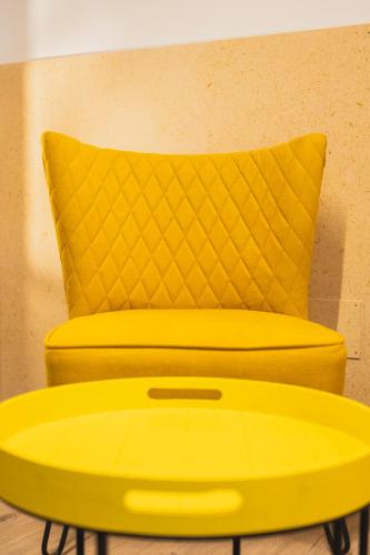a yellow chair and a yellow table with a yellow pillow at Casa de Amancio in Lavacolla